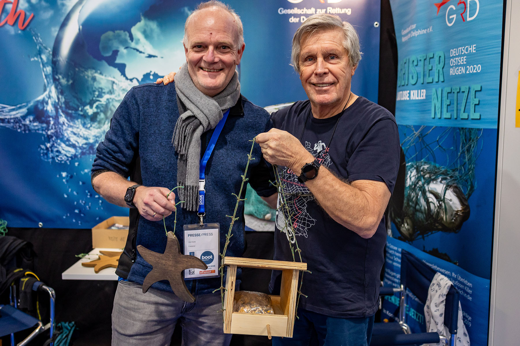 Im Rahmen der Messe „boot“ in Düsseldorf überreichte der Herforder Tischlermeister Udo Knake (l.) Futterhäuschen und „Seesterne“ mit Aufhängungen aus Geisternetzen an Schauspieler Sigmar Solbach, der sich als Vorsitzender der Gesellschaft zur Rettung der Delphine e.V. gegen die Verschmutzung der Meere einsetzt.  Bild: privat